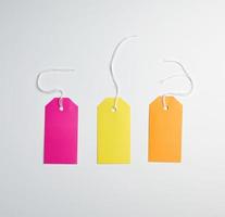 three colored paper tags on a white rope photo