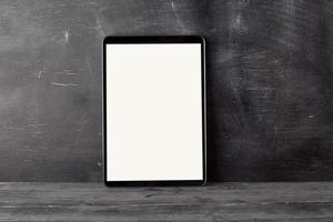 electronic tablet with a blank white screen against a black chalk board photo