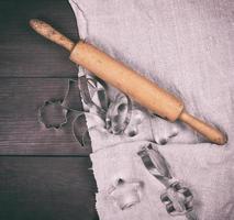 wooden rolling pin and iron bakeware on a brown wooden table photo