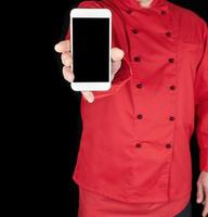 chef in red uniform holds white smartphones photo