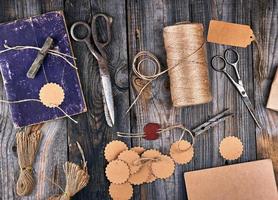 coil of brown rope, paper tags and old scissors on a gray wooden background photo