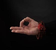 male hand shows the mudra of Knowledge on a black background photo