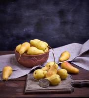 ripe yellow  pears in a brown clay bowl photo