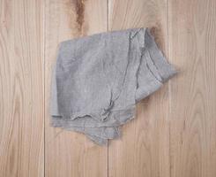 folded gray towel on brown wooden background photo