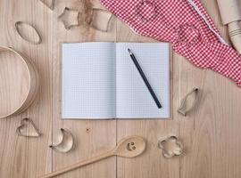 blank open notebook in line and wooden kitchen accessories photo
