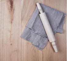 wooden rolling pin and a white textile towel photo