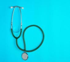 green medical stethoscope on blue background photo