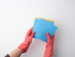 blue square absorbent sponges in their hands wearing red rubber gloves, white background photo