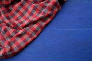 red checkered fabric on a blue wooden background photo