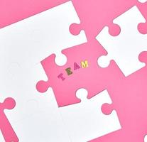 white big puzzles on a pink background,  inscription team photo