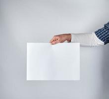 man holding a blank rectangular white paper sheet photo