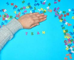 female hand and multicolored wooden letters of the English alphabet photo