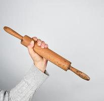 hand holding a wooden rolling pin photo