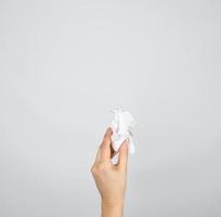 female hand holding white crumpled paper photo