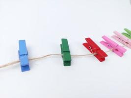 a row of rainbow colored wooden clips against a white background photo