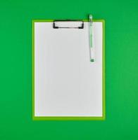 paper clipboard and pen on a green background photo