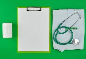 paper holder with empty white sheets, medical stethoscope photo