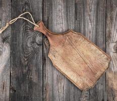 very old brown  cutting board with a handle photo