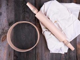 new wooden rolling pin on a textile napkin with embroidery and a round sieve photo