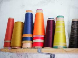 Multicolor sewing threads on wooden background.Color sewing threads on white background, top view photo