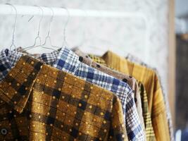 The clothes hanger is Filled with colorful Fabric shirts. shirt shop.Close Up hanging clothes photo