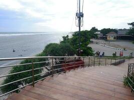 Road or bridge or wooden stairs on the beach , View of the beach bridge in Sayang Heulang Indonesia photo