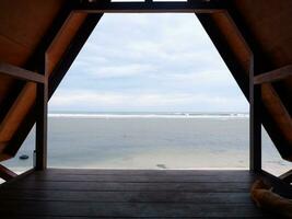 Beautiful view of the beach from inside a wooden house or gazebo photo