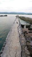 Afternoon sea view and sea-wall, beach, and coral, sunset background on Santolo beach Indonesia photo