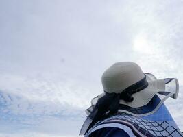 la espalda de la mujer del sombrero azul que miraba hacia el cielo azul. vista aerea foto