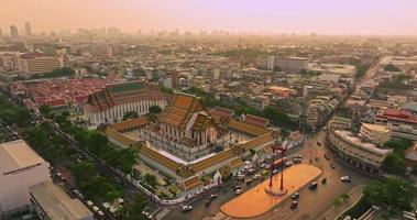 uma vista aérea do balanço do gigante vermelho e do templo suthat thepwararam na cena do pôr do sol, a atração turística mais famosa de bangkok, tailândia video