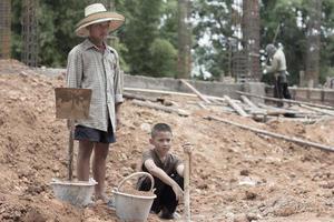 los niños se ven obligados a cavar, trabajar debido a la pobreza. violencia infantil y concepto de trata, trabajo anti-infantil, día de los derechos el 10 de diciembre. foto