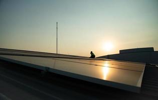 los técnicos brindan servicios de mantenimiento de celdas solares trimestrales en el techo de la fábrica foto