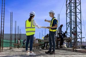 Team of engineering architect inspector and contractor having discussion while examining the quality of construction work of real estate development project concept photo