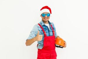 The guy, in uniform and Santa's hat, holds a drilland. Isolated on white background. photo