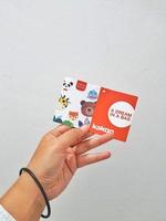 West Java, Indonesia in January 2023. Isolated white photo of a hand holding the KAKOO product brand tag