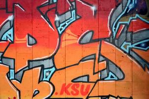 A fragment of detailed graffiti of a drawing made with aerosol paints on a wall of concrete tiles. Background image of street art in warm red color tones photo