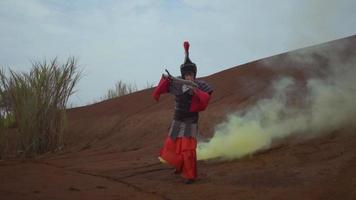 An Armored Asian Woman holding a sword when fighting the enemy in the desert in smoke video