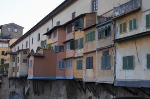 cerca de las casas multicolores en ponte vechio, viejo puente en florencia sobre el río arno foto