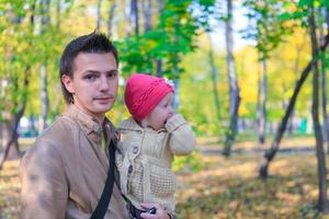 Young father walking with her little cute daughter in the autumn park outdoors photo