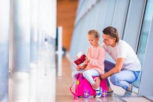 Happy family with luggage and boarding pass at airport waiting for boarding photo