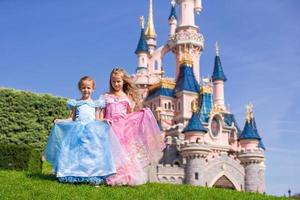 Little adorable girls in beautiful princess dress at fairy-tale park photo