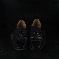 par de zapatos clásicos masculinos negros sobre fondo negro. zapatos polvorientos foto