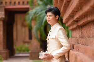 Portrait handsome man in Songkran festival with water bowl photo