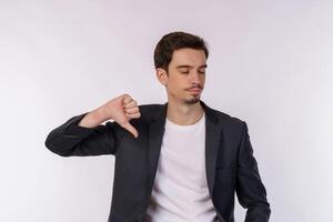 Portrait of young businessman shows sign of dislike, looks with negative expression and disapproval on isolated background photo