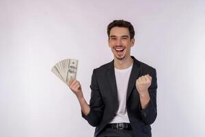 retrato de un hombre alegre que sostiene billetes de dólar y hace gesto de ganador apretando el puño sobre fondo blanco foto