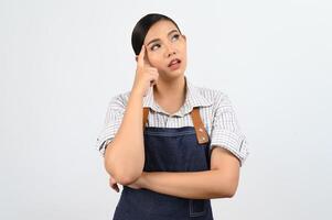 Portrait of thoughtful young asian woman in waitress costume ingenious poseture photo