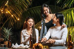 felices amigos asiáticos animando con una cena de pavo asado al aire libre - grupo de personas divirtiéndose en la fiesta de año nuevo. gente, comida y bebida concepto de estilo de vida fiesta nocturna, gente y concepto de celebración. foto