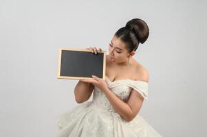 Young asian beautiful bride pose with blank blackboard in hand photo