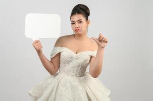 Young asian beautiful bride pose with mockup banner in hand photo