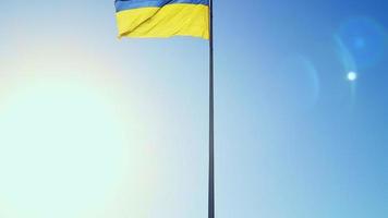 Slow motion flag of Ukraine waving in the wind against a sky without clouds at dawn of the day. Ukrainian national symbol of the country is blue and yellow. Flag loop with detailed fabric texture. photo